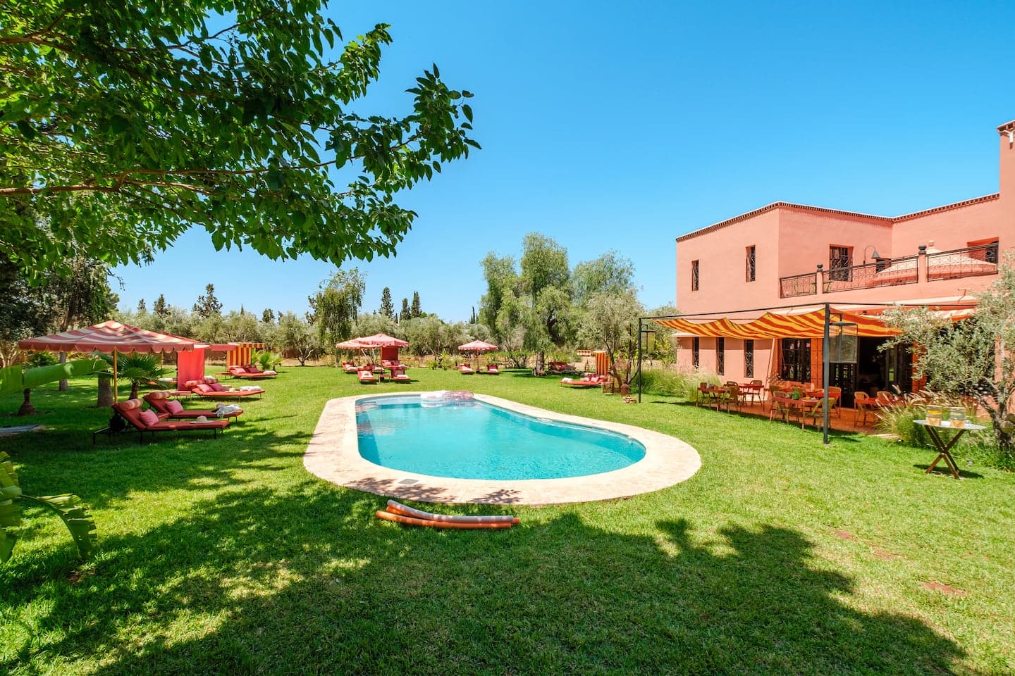 Garden pool and pink facade of Villa Samadhi